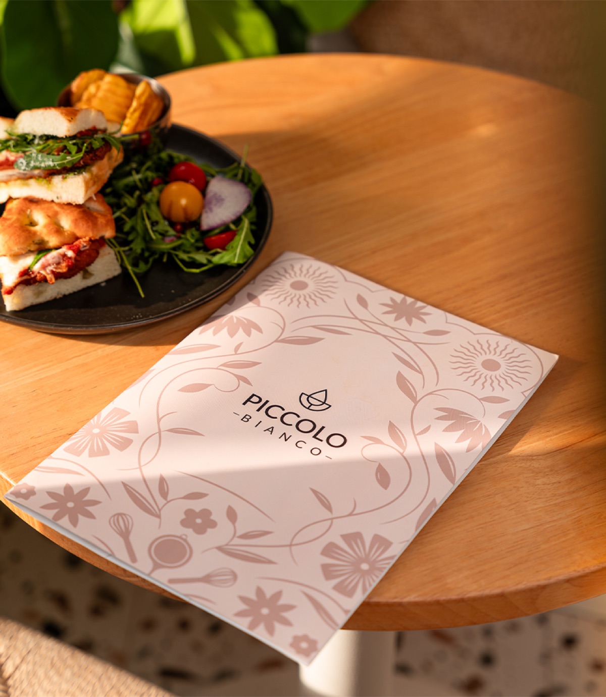 Piccolo Bianco branded menu on a table beside a focaccia plate